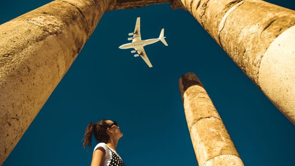 Young woman look at airplane dreaming about vacation