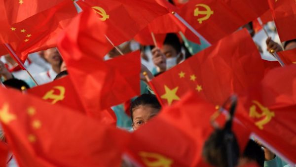 Students wave flags of China and the Communist Party of China before celebrations in Beijing on July 1, 2021, to mark the 100th anniversary of the founding of the Communist Party of China. 