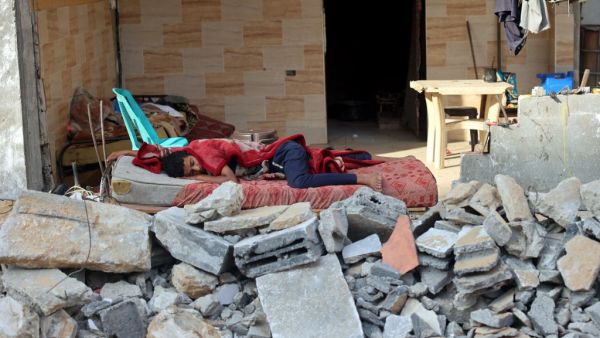 A Palestinian boy sleeps in the ruins of his family house that was destroyed in Israeli air strikes during the most recent Israeli-Palestinian fighting, in Gaza City