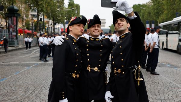 Pupils of the Ecole Polytechnique (Special military school of Polytechnique) pose for a picture as preparations are made for the annual Bastille Day military parade on the Champs-Elysees avenue in Paris 