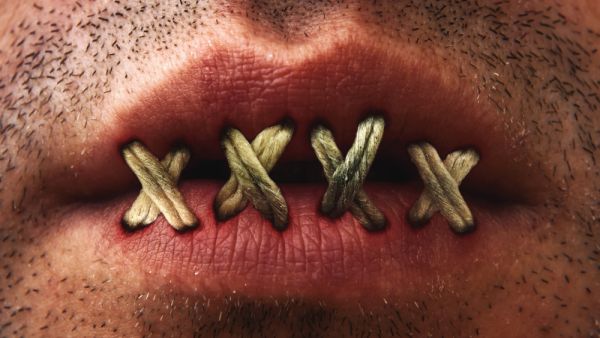 Close up of mans mouth with lips stitched or sewn shut