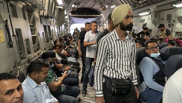 Indian Nationals sit aboard an Indian military aircraft 