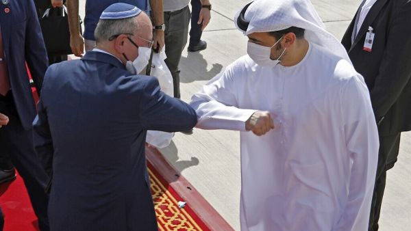 National Security Adviser Meir Ben-Shabbat elbow bumps with an Emirati official ahead of boarding the plane before leaving Abu Dhabi