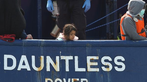 A girl stands onboard the DHB Dauntless tug boat as a group of migrants are brought to shore by the UK Border Force after illegally crossing the English Channel from France on a dinghy on September 11, 2020, in the marina at Dover, on the south coast of England. AFP / BEN STANSALL Is UK fuel shortages related to migration?