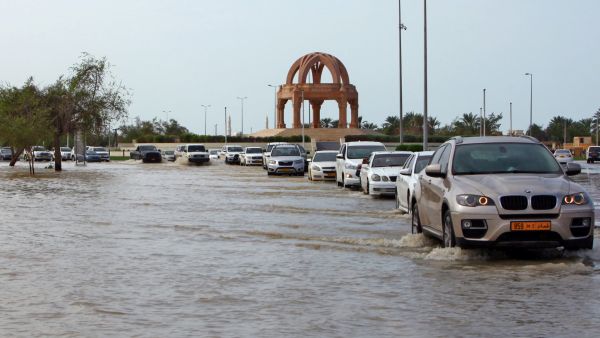 Vehicles make their way through a flooded street in the aftermath of tropical Cyclone Shaheen in Oman's northern town of al-Mussanah on October 4, 2021. (Photo by MOHAMMED MAHJOUB / AFP) Tropical Cyclone Shaheen killed 13 people