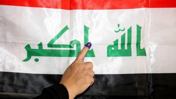 Iraqi woman places her finger on the Iraqi flag