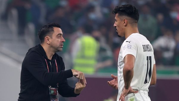 Sadd's coach Xavi (L) speaks to Sadd's forward Baghdad Bounedjah (R) during the Amir Cup final football match between Al-Sadd and Al-Rayyan at the Al-Thumama Stadium in the capital Doha on October 22, 2021. (Photo by KARIM JAAFAR / AFP)