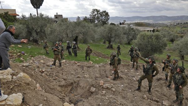 Palestinians residents confront Israeli soldiers in Burqa