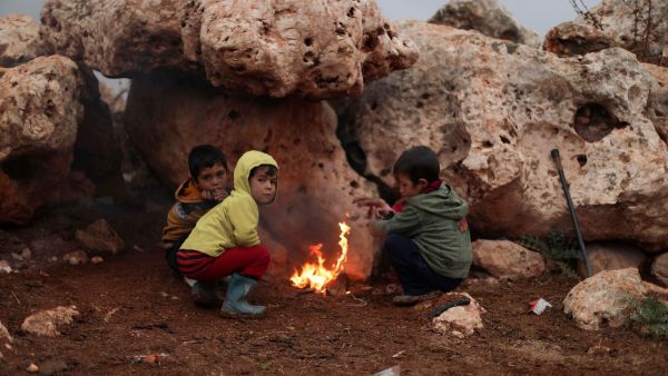 Children on November 20, 2021, gather in front of a camp fire, in the Bardaqli camp for displaced people in the town of Dana in Syria's northwestern Idlib province, as winter approaches on the International Day of Children's Rights. (Photo by AAREF WATAD / AFP) Amnesty calls for repatriation of 27,000 children held at Syrian camp