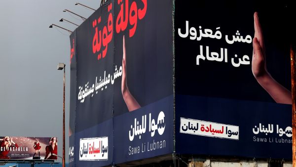 This picture taken on December 8, 2021 shows an anti-corruption billboard with the Arabic slogan "a strong state, not an intransigent militia" on display on the side of a highway in Lebanon's coastal city of Jounieh, north of the capital. (Photo by JOSEPH EID / AFP) Lebanon to hold parliamentary elections on May 15