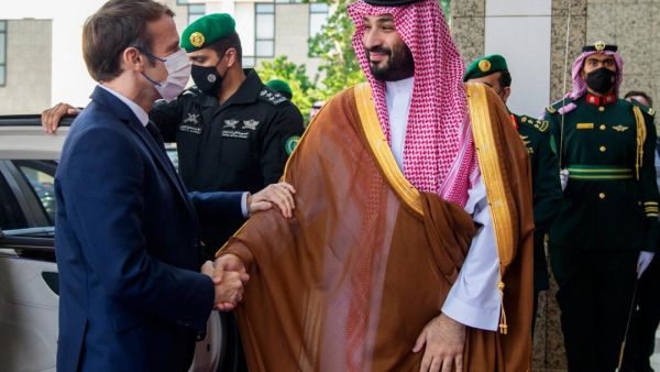 Macron (L) is greeted by Mohammed bin Salman 