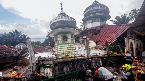 Villagers try to communicate with the victims under the rubble of a mosque, in West Pasaman, on February 25, 2022, after a magnitude 6.2 earthquake hit the area and damaged hundreds of houses and public facilities. (Photo by Ardhy FERNANDO / AFP) strong earthquake