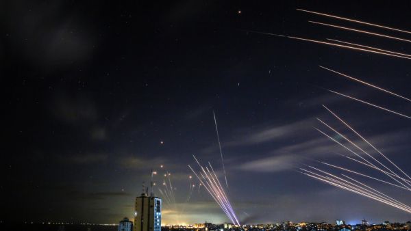 In the background the Israeli Iron Dome missile defence system (L) intercepts rockets (R) fired by the Hamas movement towards southern Israel from Beit Lahia in the northern Gaza Strip. AFP / ANAS BABA Iron Dome