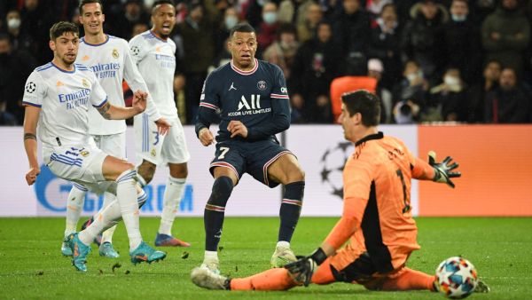 PSG's French forward Kylian Mbappe (C) shoots and scores a goal during the UEFA Champions League round of 16 first leg football match between PSG and Real Madrid at the Parc des Princes stadium in Paris on February 15, 2022. (Photo by Alain JOCARD / AFP)