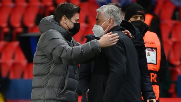 PSG's Argentinian head coach Mauricio Pochettino (L) greets Real Madrid's Italian coach Carlo Ancelotti (R) as they arrive prior to the UEFA Champions League round of 16 first leg football match between Paris Saint-Germain (PSG) and Real Madrid at the Parc des Princes stadium in Paris on February 15, 2022. (Photo by FRANCK FIFE / AFP)