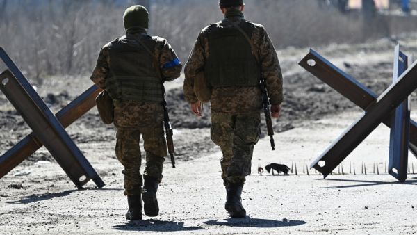 Ukrainian soldiers walk on the front line, near Kyiv, on March 20, 2022. (Genya SAVILOV / AFP) Ukrainian soldiers walk on the front line