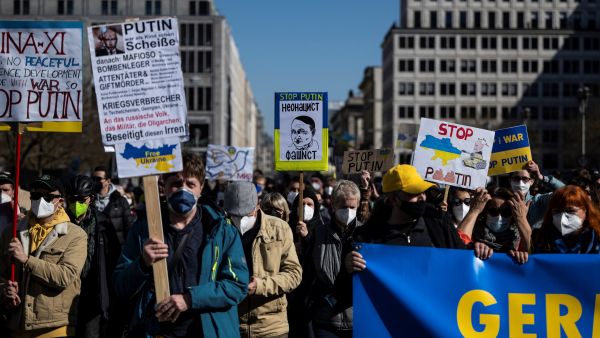 In this file photo taken on March 13, 2022 a protester displays a placard featuring a caricature of Russian President Vladimir Putin as Germany's genocidal WWII Nazi dictator Adolf Hitler during a demonstration against Russia's invasion of the Ukraine in Berlin. John MACDOUGALL / AFP EU approves new set of sanctions against Russia