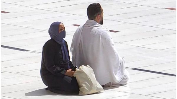 فتاة تستظل بشقيقها في الحرم المكي 