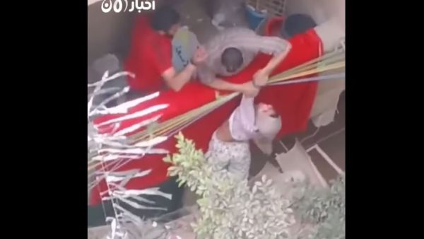  اللقطات تصور رجلا يحاول "تأديب" ابنته من خلال تهديدها بإلقائها من الشرفة.
