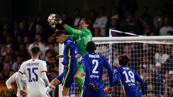 Real Madrid's Belgian goalkeeper Thibaut Courtois (C) catches the ball during the UEFA Champions League Quarter-final first leg football match between Chelsea and Real Madrid at Stamford Bridge stadium in London, on April 6, 2022. (Photo by Adrian DENNIS / AFP)