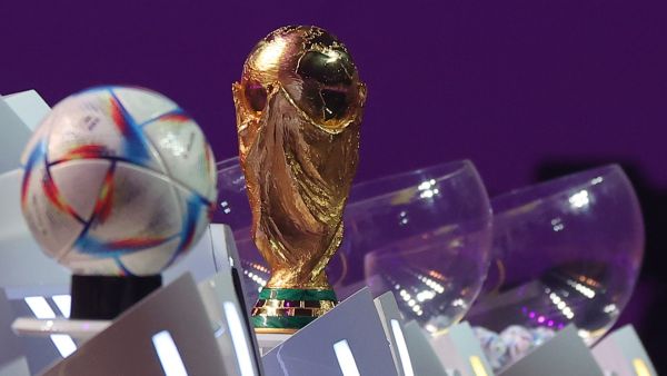The FIFA World Cup trophy and the official 2022 World Cup ball called Al-Rihla, which means "the journey" in Arabic, are seen on stage during the draw for the 2022 World Cup in Qatar at the Doha Exhibition and Convention Center on April 1, 2022. (Photo by KARIM JAAFAR / AFP)