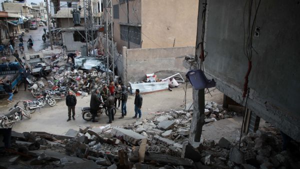 Syrians stand next to a destroyed building in Balyun in Syria's northwestern Idlib province, on December 8, 2019, the day after a reported Russian airstrike on a market in the village. AFP / Aaref WATAD 2019 airstrike in Syria