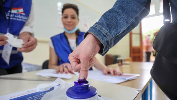 A voter dips her finger in ink after casting her ballot in the parliamentary election at a polling station in the capital Beirut, on May 15, 2022. (Photo by anwar amro / AFP) parliamentary election