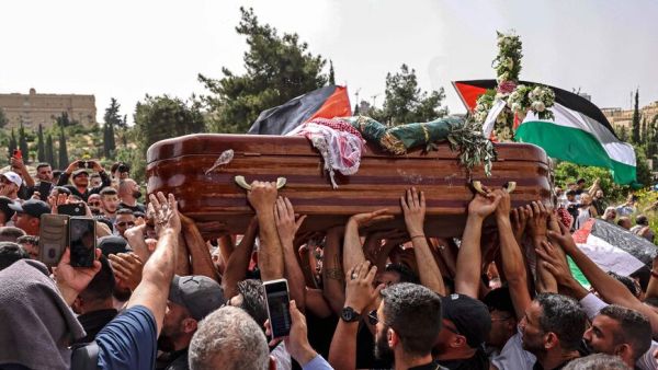 Palestinian mourners carry the casket of slain Al-Jazeera journalist 