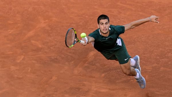 Spain's Carlos Alcaraz returns the ball to Germany's Alexander Zverev during their 2022 ATP Tour Madrid Open tennis tournament men's singles final match at the Caja Magica in Madrid. At just 19, Carlos Alcaraz is bidding to become just the eighth teenager to win a Grand Slam men's singles title at the French Open which gets underway at Roland Garros on May 22, 2022. (Photo by JAVIER SORIANO / AFP)