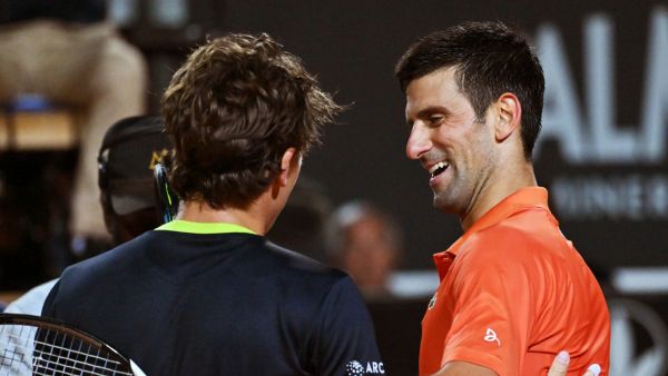 Serbia's Novak Djokovic (R) and Norway's Casper Ruud embrace after Djokovic won their semifinal match at the ATP Rome Open tennis tournament on May 14, 2022 at Foro Italico in Rome. (Photo by Andreas SOLARO / AFP)