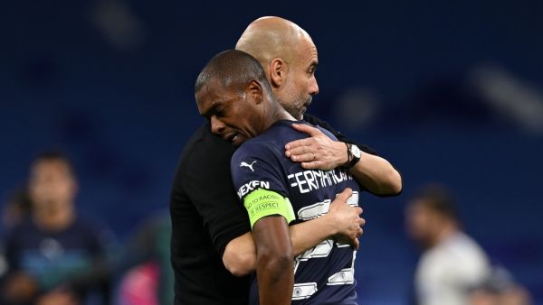Manchester City's Spanish manager Pep Guardiola (L) hugs Manchester City's Brazilian midfielder Fernandinho after the UEFA Champions League semi-final second leg football match between Real Madrid CF and Manchester City at the Santiago Bernabeu stadium in Madrid on May 4, 2022. Real Madrid won the match 3-1. (Photo by Paul ELLIS / AFP)
