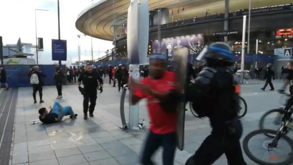 This grab taken from an AFP video shows the police intervening as fans climb the fence of the Stade de France before the UEFA Champions League final football match between Liverpool and Real Madrid at the Stade de France in Saint-Denis, north of Paris, on May 28, 2022. (Photo by Maryam EL HAMOUCHI / AFP)