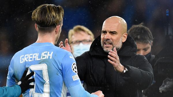 Manchester City's Spanish manager Pep Guardiola (R) speaks with Manchester City's English midfielder Jack Grealish on the pitch after the UEFA Champions League Quarter-final first leg football match between Manchester City and Atletico Madrid at the Etihad Stadium in Manchester, north west England, on April 5, 2022. Manchester City won the game 1-0. (Photo by Oli SCARFF / AFP)