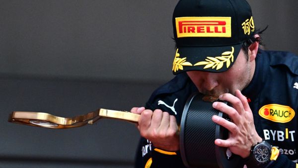 Red Bull Racing's Mexican driver Sergio Perez kisses his trophy on the podium after winning the Monaco Formula 1 Grand Prix at the Monaco street circuit in Monaco, on May 29, 2022. (Photo by SEBASTIEN BOZON / AFP)