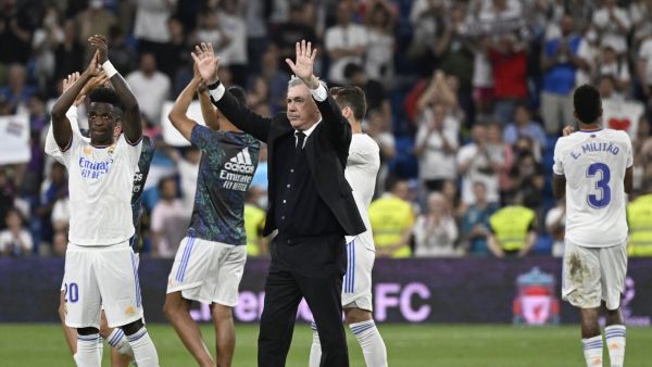 Real Madrid's Italian coach Carlo Ancelotti (C), Real Madrid's Brazilian forward Vinicius Junior (L) and teammates acknowledge the crowd at the end of the Spanish league football match between Real Madrid CF and Real Betis at the Santiago Bernabeu stadium in Madrid on May 20, 2022. (Photo by Pierre-Philippe MARCOU / AFP)