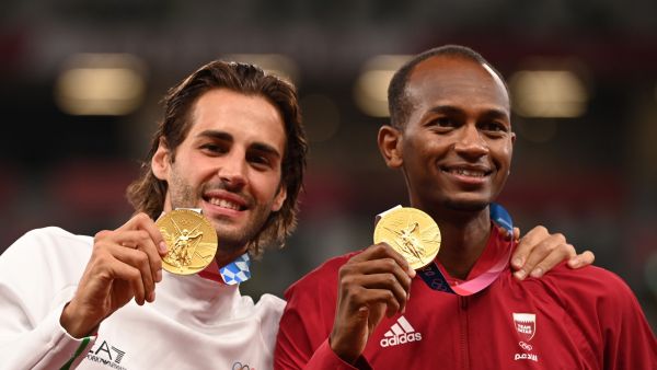 Joint gold medalists Qatar's Mutaz Essa Barshim (R) and Italy's Gianmarco Tamberi pose on the podiumn of the men's high jump final during the Tokyo 2020 Olympic Games at the Olympic Stadium in Tokyo on August 2, 2021. (Photo by Ina FASSBENDER / AFP)