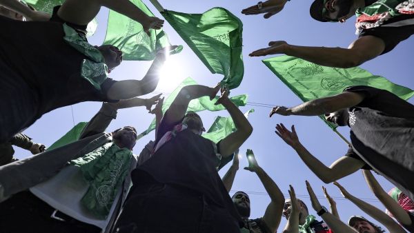 Palestinian students supporting the Islamic Hamas movement wave the movement's flag as they celebrate a victory in student elections at Birzeit University on the outskirts of Ramallah in the occupied West Bank on May 19, 2022. (Photo by ABBAS MOMANI and ABBAS MOMANI / AFP) Hamas: Unity, resistance only way to fight Israeli occupation, foil its plots