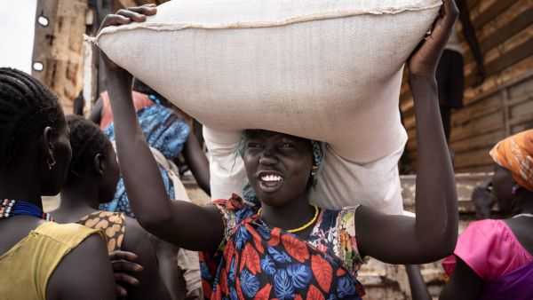 A woman from Murle ethnic group carries a bag of sorghum during a food distribution by United Nations World Food Programme (WFP) in Gumuruk, South Sudan, on June 10, 2021, as her village where recently attacked by armed youth group. AFP / Simon Wohlfahrt South Sudan