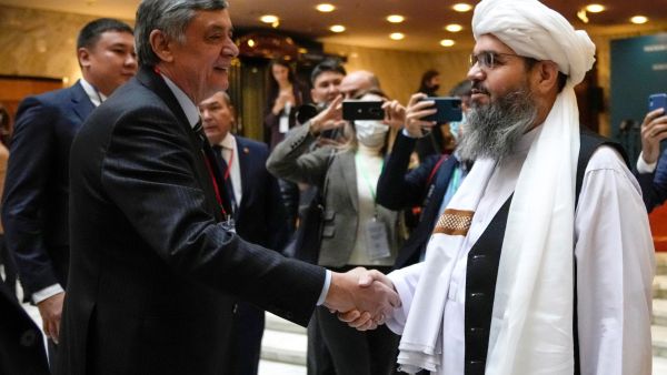 Russian presidential envoy to Afghanistan Zamir Kabulov (L) shakes hands with a member of the Taliban delegation Mawlawi Shahabuddin Dilawar prior to an international conference on Afghanistan in Moscow on October 20, 2021. (Photo by Alexander Zemlianichenko / POOL / AFP) Taliban government