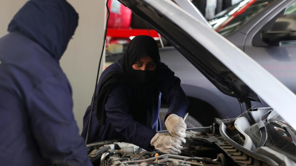 Ghada Ahmed (R) works on a car in Saudi Arabia