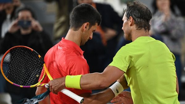 Spain's Rafael Nadal (R) shakes hands with Serbia's Novak Djokovic (L) after winning at the end of their men's singles match on day ten of the Roland-Garros Open tennis tournament at the Court Philippe-Chatrier in Paris early June 1, 2022. (Photo by Anne-Christine POUJOULAT / AFP)