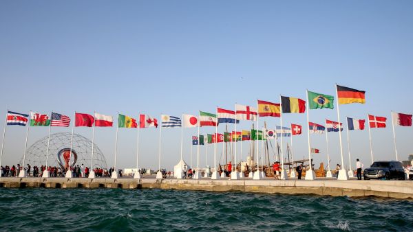 A general view shows flags of the qualified countries for the 2022 World Cup in the Qatari capital Doha during a flag-raising ceremony of the last remaining countries to qualify, on June 16, 2022. (Photo by Mustafa ABUMUNES / AFP)
