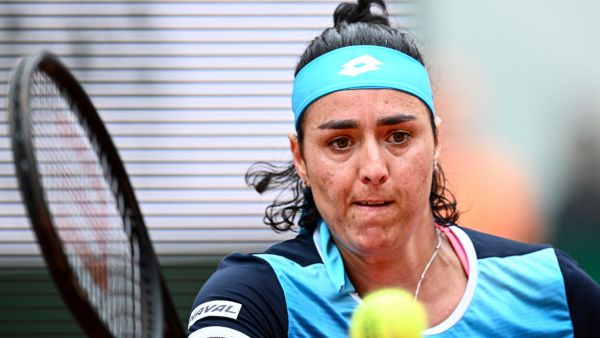 Tunisia's Ons Jabeur plays a forehand return to Poland's Magda Linette during their women's singles match on day one of the Roland-Garros Open tennis tournament at the Court Philippe-Chatrier in Paris on May 22, 2022. (Photo by Anne-Christine POUJOULAT / AFP)