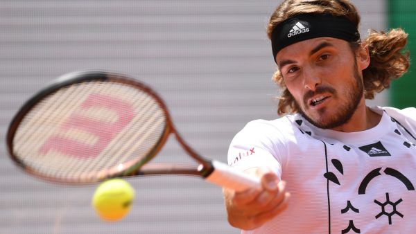 Greece's Stefanos Tsitsipas returns the ball to Denmark's Holger Rune during their men's singles match on day nine of the Roland-Garros Open tennis tournament at the Court Philippe-Chatrier in Paris on May 30, 2022. (Photo by JULIEN DE ROSA / AFP)