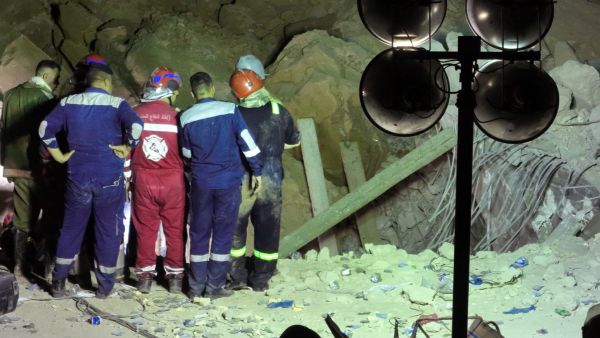 An aerial picture shows members of Iraqi emergency services gathering near the rubble following a landslide at the Qattarat al-Imam Ali shrine on the outskirts of the holy city of Karbala, late on August 20, 2022. (Photo by Mohammed SAWAF / AFP) Karbala