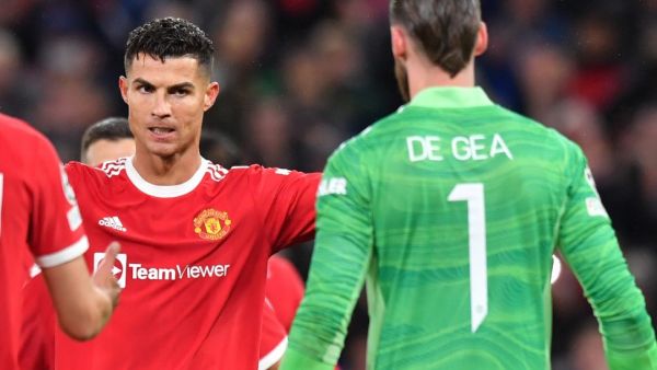 Manchester United's Portuguese striker Cristiano Ronaldo celebrates with Manchester United's Spanish goalkeeper David de Gea at the final whistle in the UEFA Champions league group F football match between Manchester United and Villarreal at Old Trafford stadium in Manchester, north west England, on September 29, 2021. Manchester United won the match 2-1. (Photo by Anthony Devlin / AFP)