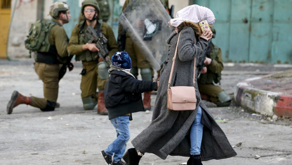 Palestinian woman, Israeli soldiers in Hebron
