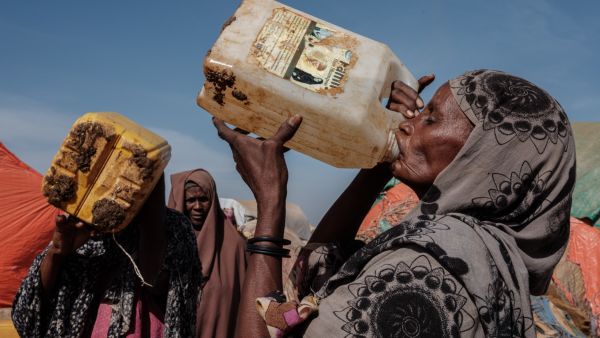 In this file photo taken on February 13, 2022 Hawa Mohamed Isack (R), 60, drinks water at a water distribution point at Muuri camp, one of the 500 camps for internally displaced persons (IDPs) in town, in Baidoa, Somalia. (Photo by YASUYOSHI CHIBA / AFP) Drought Funds