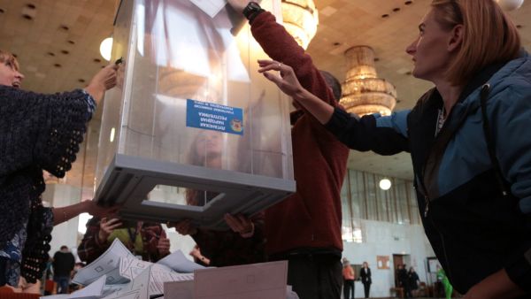 Election commission members count votes of refugees from Russian-held regions of Ukraine for a referendum at a polling station in Simferopol, Crimea, on September 27, 2022. (Photo by STRINGER / AFP) annexation votes