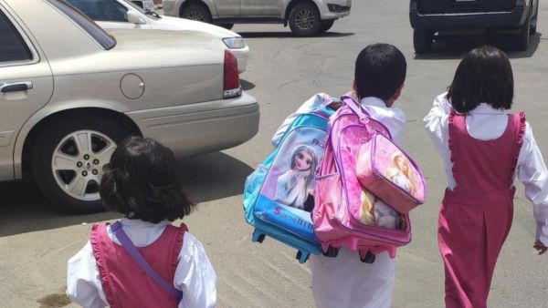الطفل مشعل الشهراني يحمل حقائب شقيقته